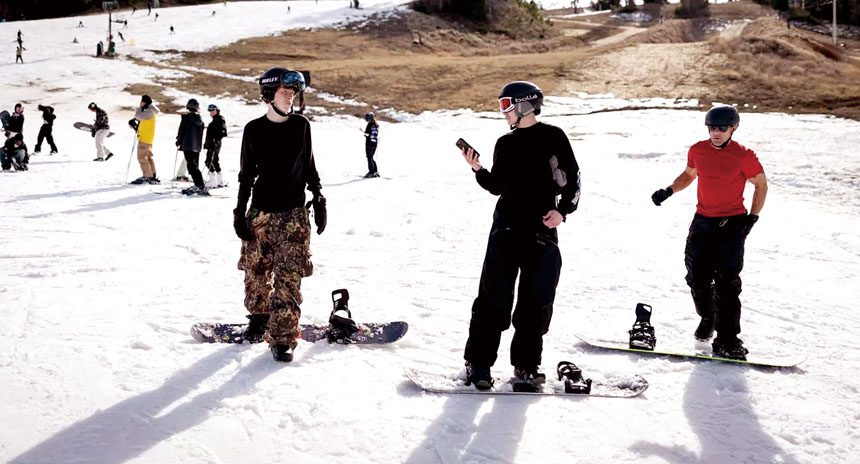 愛德華茲(Bevin Edwards)（右）和兒子菲尼克斯(Phoenix Edwards)（中）站在大熊山度假村的一條滑雪道底部。洛杉磯時報