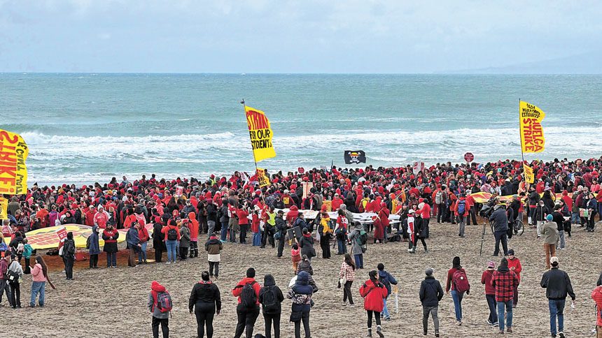 教師罷工第三天，數千名教師與家長冒雨在Ocean Beach排出「FOR OUR STUDENTS STRIKE」標語。記者蘇婕雅攝