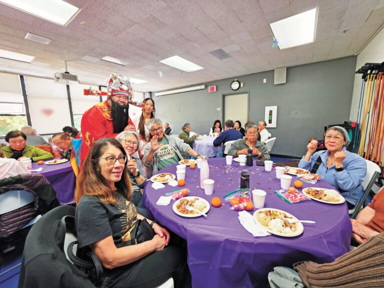 長者用餐點揭幕禮上，財神向享用午餐的長者派發利是與賀年禮品。受訪者提供