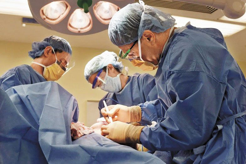 外科醫生為一名跨性別患者進行雙側乳房切除術。 美聯社